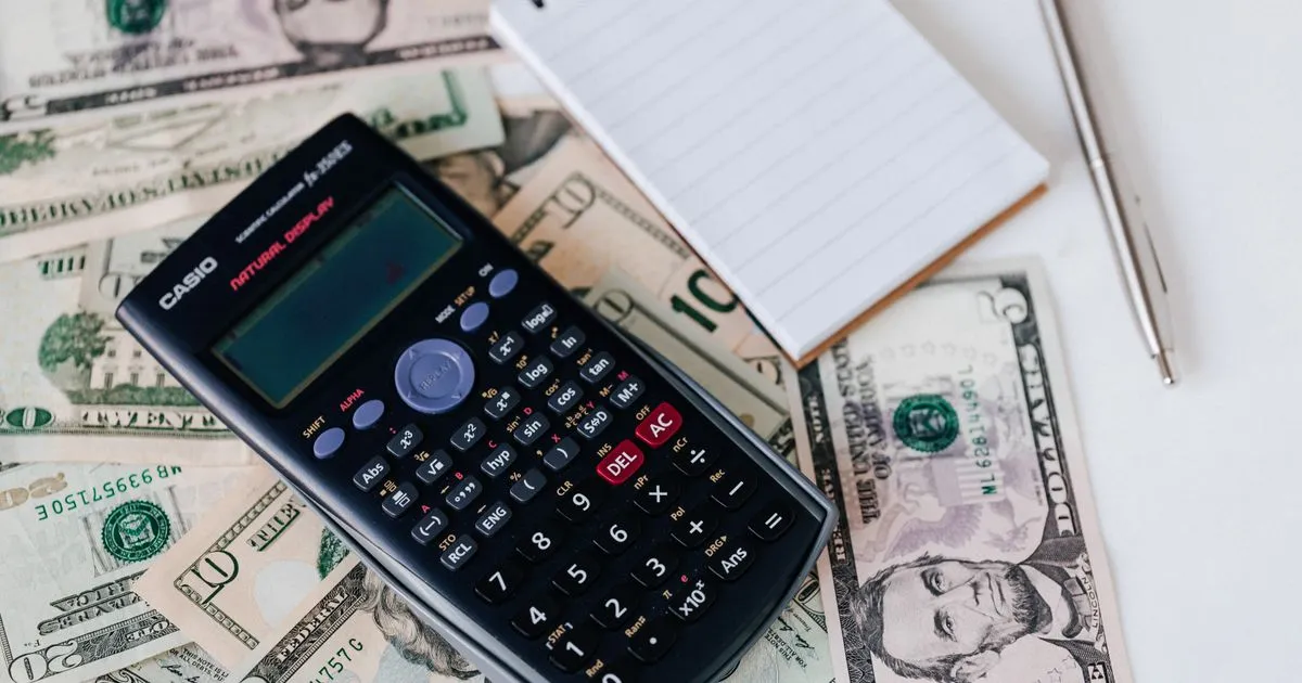 Two laptops side by side comparing contractor payment platform pricing