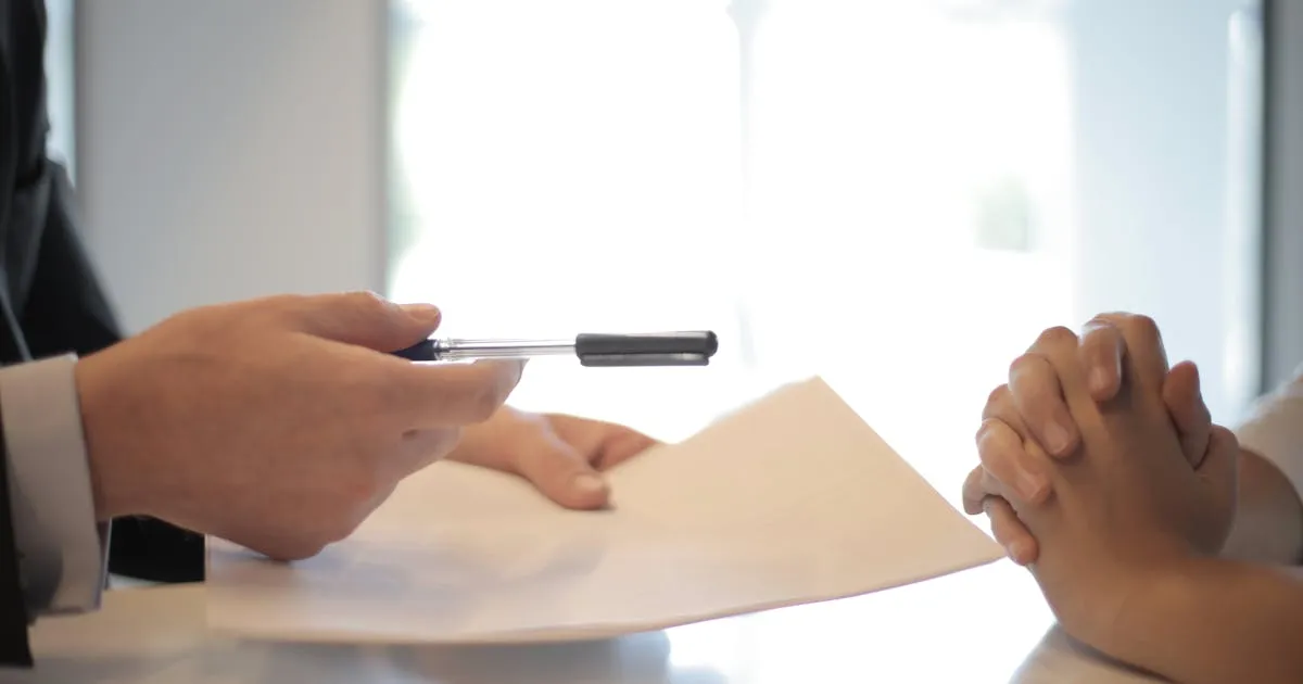 Designer reviewing brand identity work on a tablet next to printed proofs