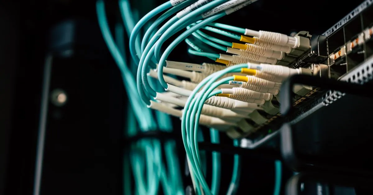 DevOps engineer in India operating cloud infrastructure racks in a Bengaluru data centre under blue lighting