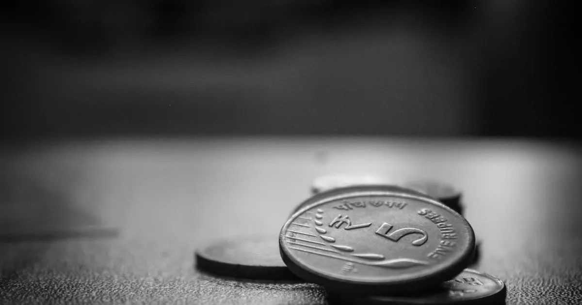 Stacked Indian five rupee coins representing minimum wage