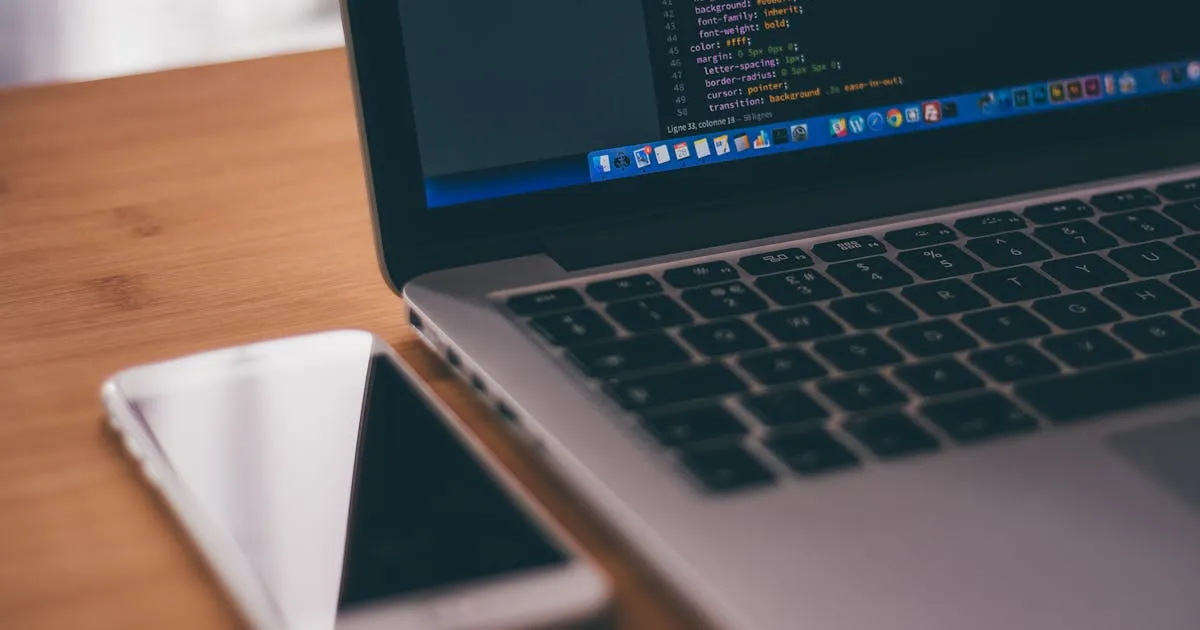 Laptop with code and smartphone, mobile developer workspace