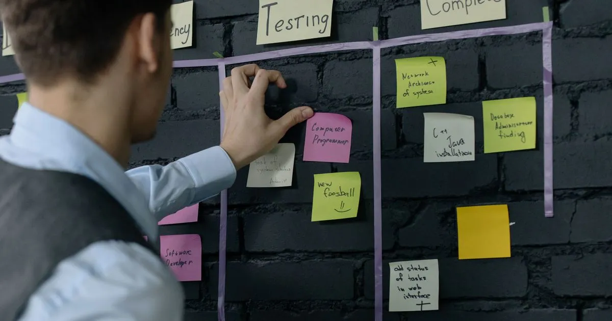 Product manager organizing sticky notes on a project board